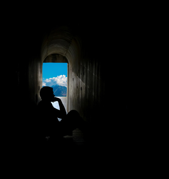 Siluetti mies istuu tunnelissa
 - Valokuva, kuva