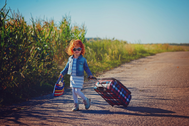 Happy Little Curly Girl   with suitcases. vacation and trip concept. freedom and wind. girl traveler. Summer time. - 写真・画像