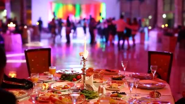 Grupo de pessoas desfocadas dançando em um salão de banquetes escuro para uma recepção de casamento
 - Filmagem, Vídeo