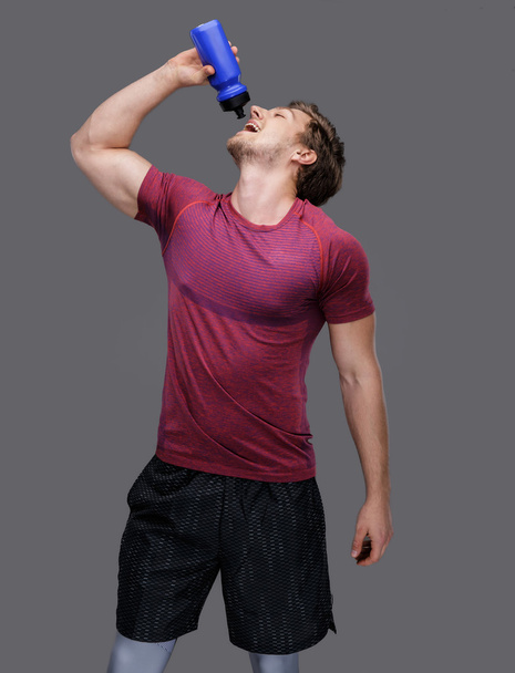 man holds bottle of water - Φωτογραφία, εικόνα