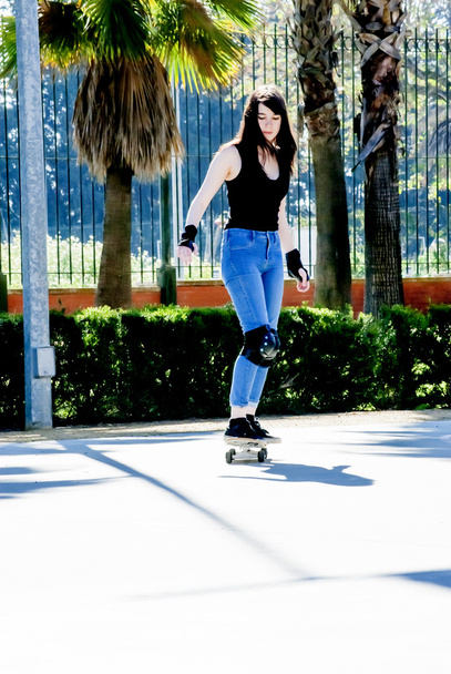 Beautiful young woman practicing with the skateboard on the street - Fotoğraf, Görsel