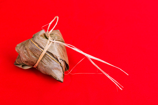 Свежий китайский рисовый пельмень или зонци на красном фоне
 - Фото, изображение