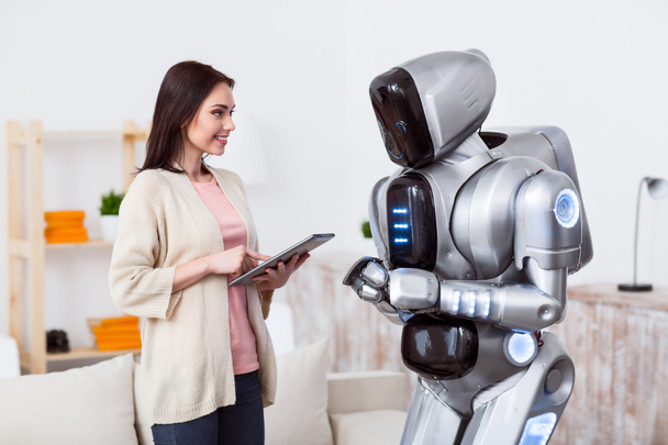 Positive girl standing with the robot - Foto, Bild
