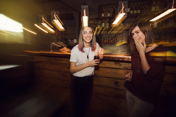 Две счастливые девушки веселятся в баре
 - Фото, изображение