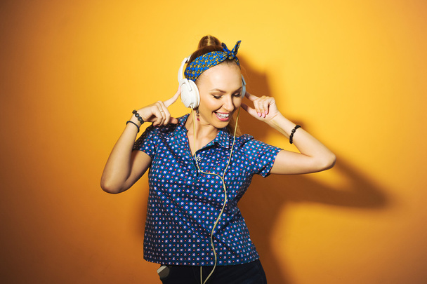 Young girl wearing headphones listening to music, singing and posing - Zdjęcie, obraz