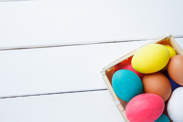 пасхальные яйца в корзине на деревянном столе. happy easter
 - Фото, изображение