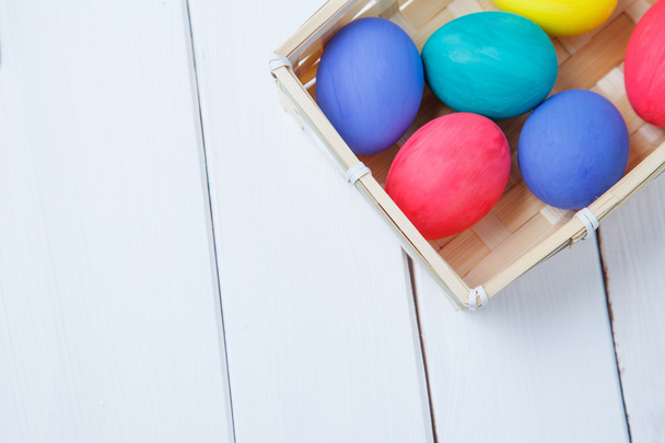 Пастельные и красочные пасхальные яйца в корзине. happy easter
 - Фото, изображение