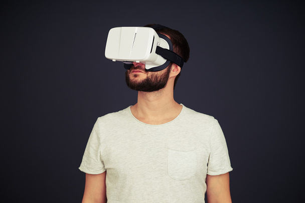 Man op zoek rond het gebruik van virtual reality bril - Foto, afbeelding