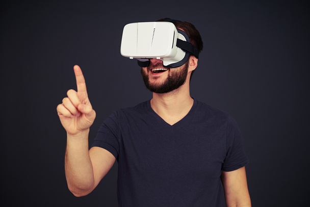 Homme toucher quelque chose en utilisant des lunettes de réalité virtuelle
 - Photo, image