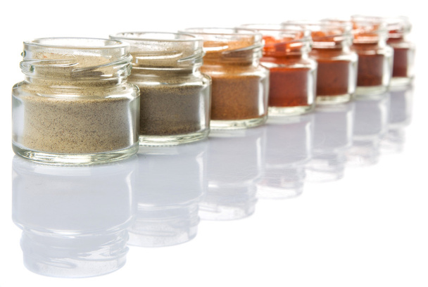 Hot and spicy spices powder, cayenne powder, chilly powder, peppercorn powder, paprika powder, black pepper and white pepper powder in small mason jar over white background - Photo, Image