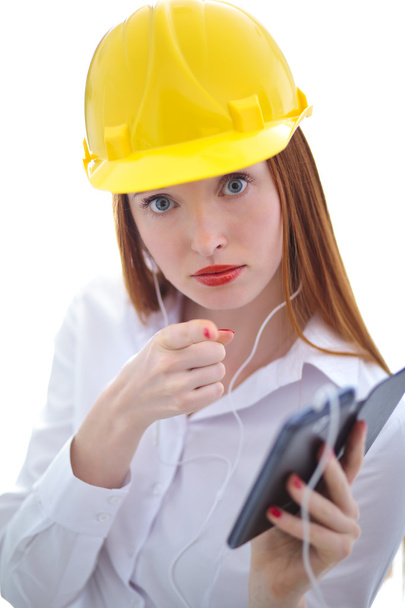 junge schöne Frau mit gelbem Helm mit einem Handy - Foto, Bild