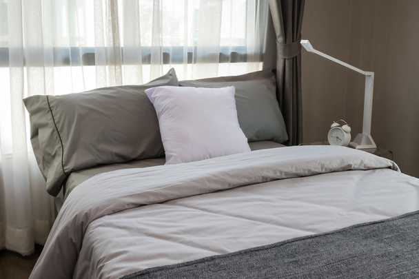 moderno dormitorio de lujo con almohadas y lámpara
 - Foto, imagen