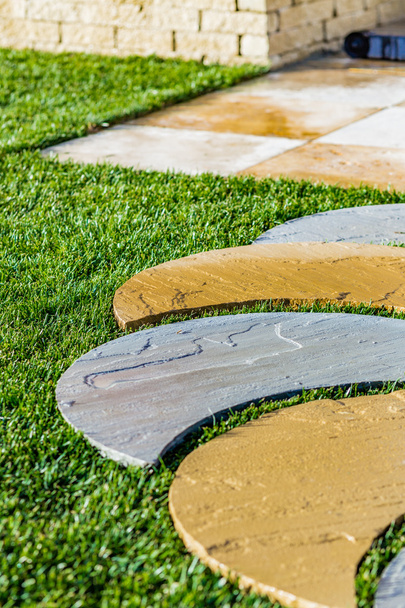 passos de pedra dispostos na grama
 - Foto, Imagem