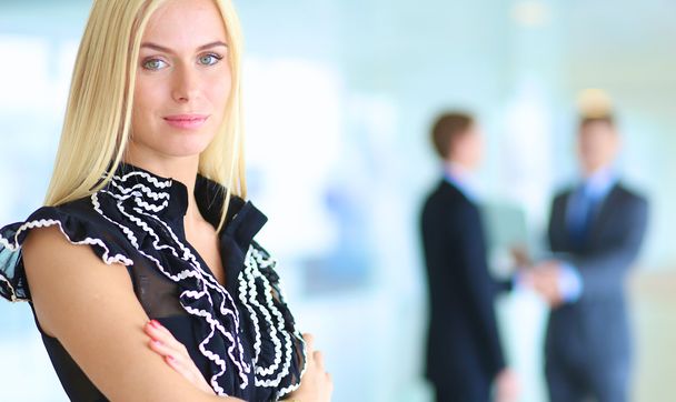 Business woman standing in foreground  in office - Photo, Image