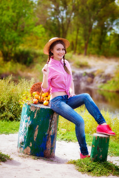 Девушка в соломенной шляпе и яблоках осенью у реки
 - Фото, изображение
