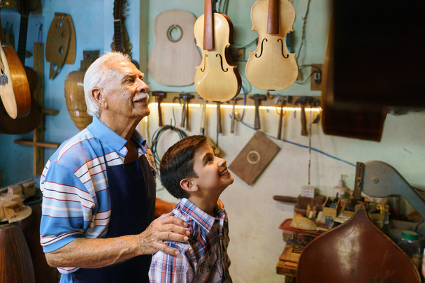 vieil homme grand-père montrant la guitare à garçon petit-fils
 - Photo, image