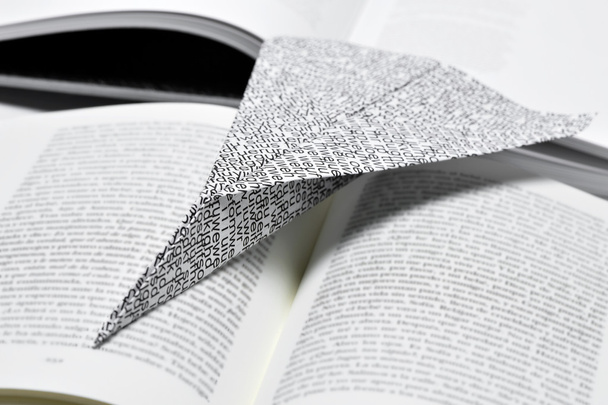 avião de papel em um livro aberto
 - Foto, Imagem