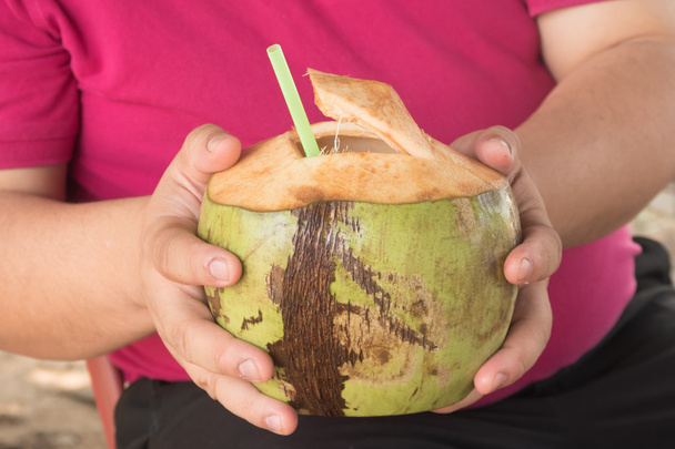 Мужчина представляет очищенный кокос
 - Фото, изображение