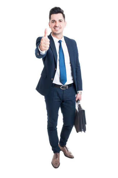 Confident businessman wearing blue suit and briefcase showing li - Фото, изображение