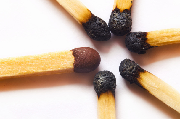 Single match standing out against burned matches - Foto, imagen