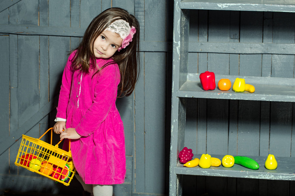 Little girl with plastic fruits and vegetables - Valokuva, kuva