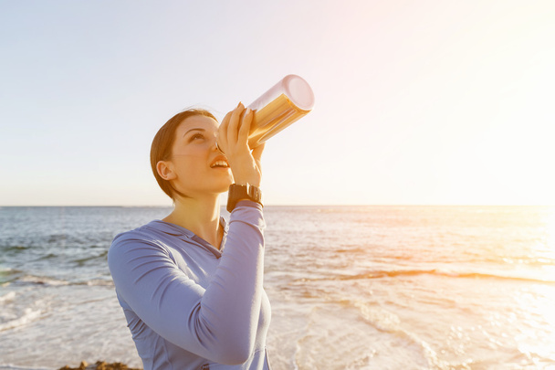 Woman drinking water on beach - Foto, Imagen