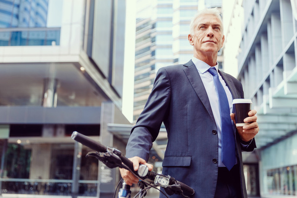 Successful businessman riding bicycle - Zdjęcie, obraz