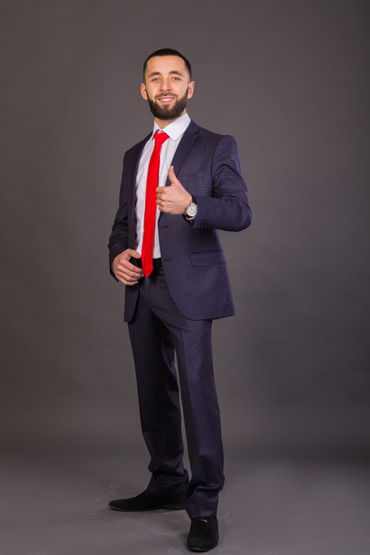 Молодий бізнесмен. Чоловік у гарному костюмі, біла сорочка, червона краватка
. - Фото, зображення