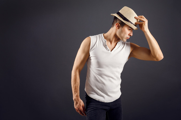 Мужчина модель, стильный молодой человек в шляпе в шляпе в шляпе стоя, на черном фоне
 - Фото, изображение