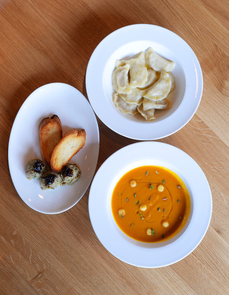 Bovenaanzicht van tabel met kom vol varenyky, soep en croutons  - Foto, afbeelding