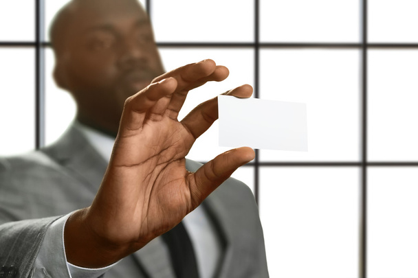 Black male shows visit card. - Foto, afbeelding
