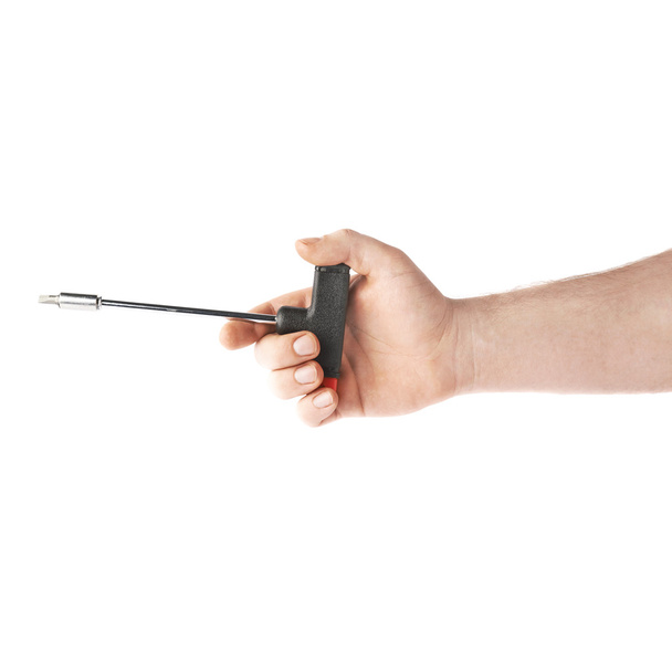 Hand holding a T-shape screwdriver tool, composition isolated over the white background - Zdjęcie, obraz