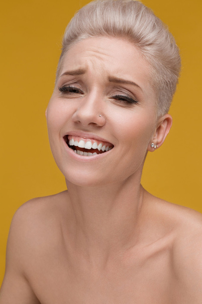 emotions of a young woman on a yellow background, smile - Foto, imagen