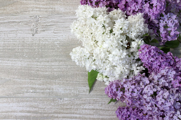 Closeup of purple and white lilac flowers on wooden table  - Photo, Image