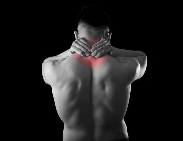 back young muscular sport man holding sore neck touching massaging cervical area  - Photo, Image