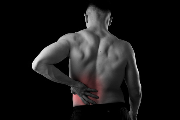 young muscular body sport man holding sore low back waist are suffering pain in athlete stress - 写真・画像