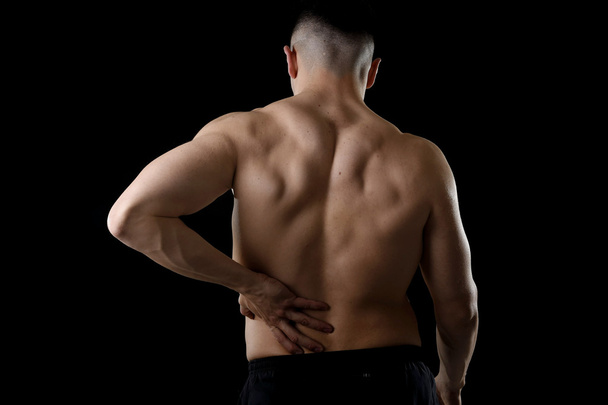 young muscular body sport man holding sore low back waist are suffering pain in athlete stress - Photo, image