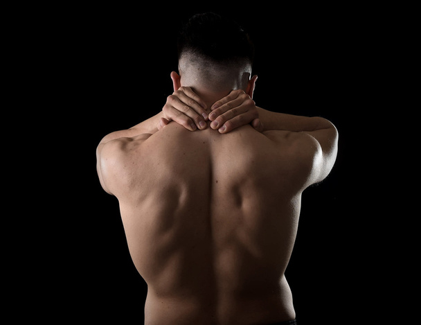 young muscular sport man holding sore neck massaging cervical area suffering body pain - Zdjęcie, obraz