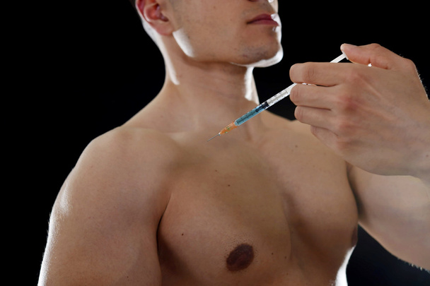young body building sportsman using steroids for increasing sport and athletic  performance injecting syringe shoulder - Foto, afbeelding