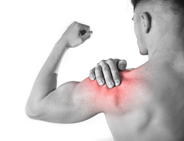 joven musculoso hombre deportivo sosteniendo dolor en el hombro tocando masaje en el estrés de entrenamiento
 - Foto, Imagen