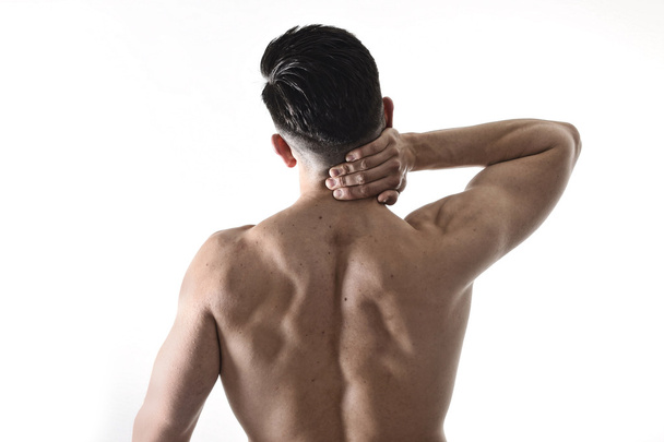young muscular sport man holding sore neck massaging cervical area suffering body pain - Fotografie, Obrázek