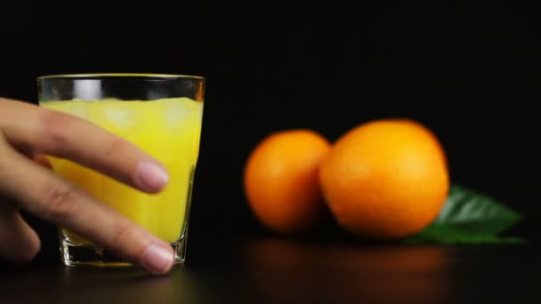 ein Mann trinkt einen Cocktailschraubenzieher auf schwarzem Hintergrund - Filmmaterial, Video