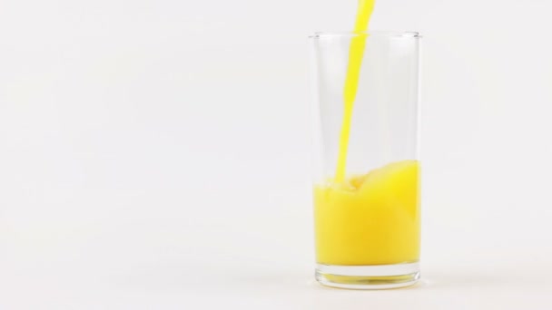 Mann gießt Orangensaft in ein Glas auf weißem Hintergrund - Filmmaterial, Video