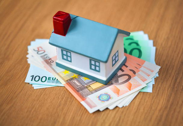 Banknoty euro i symboliczne mały dom (kupna nieruchomości, kredytów hipotecznych) - Zdjęcie, obraz