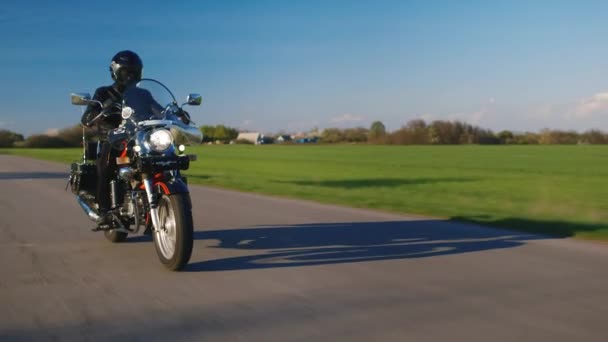 Motorcycle riding on a background of green field and blue sky - Footage, Video