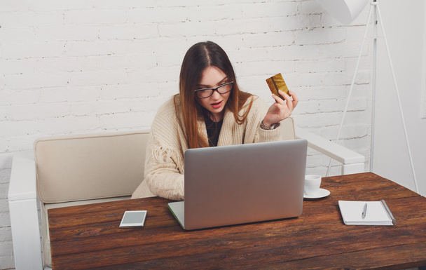 junge Frau mit Brille beim Online-Shopping zu Hause - Foto, Bild