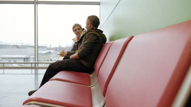Pár, čekající na letišti terminál s lístky - Záběry, video