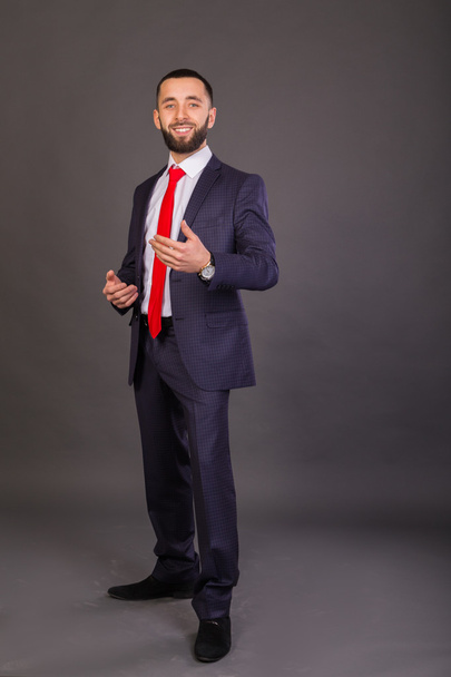 Молодой бизнесмен. Мужчина в красивом костюме, белой рубашке, красном галстуке
. - Фото, изображение