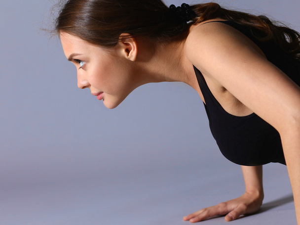 Portrait of young woman doing push ups - Foto, Imagem