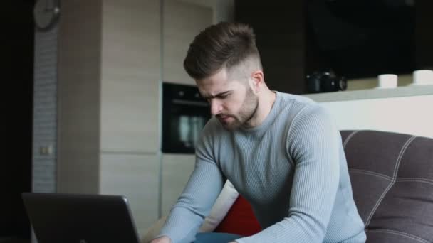 sexy bonito homem usando seu laptop descansando no seu fantasia apartamento
 . - Filmagem, Vídeo